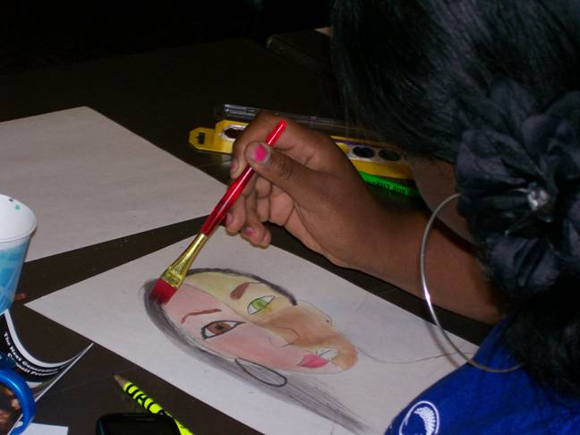 Briana, 14, puts the finishing touches on her masterpiece during the “Expressions through Art” breakout session.