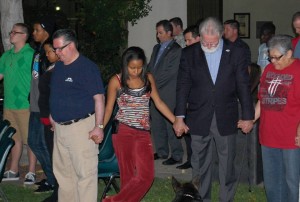 Mayor R. Rex Parris holds hands with residents as prayers are offered.