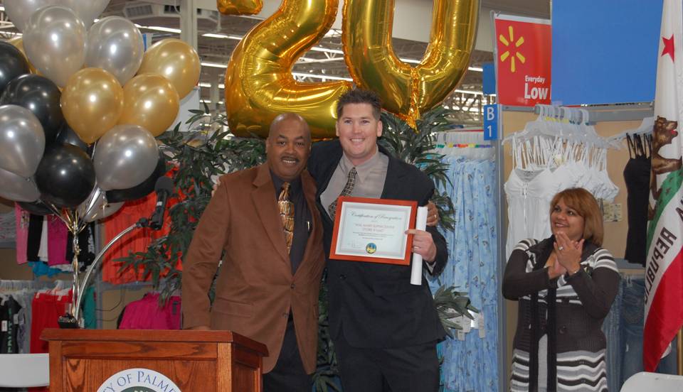 Walmart store manager Trent Blankenship(R) receives a certificate of appreciation from Antelope Valley Black Chamber of Commerce president Richard Poston(L) at a ceremony Wednesday celebrating Walmart's 20 years of business in Palmdale.