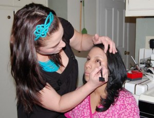 Tiffany Derosier applies make-up to caregiver Jennifer Nazario.