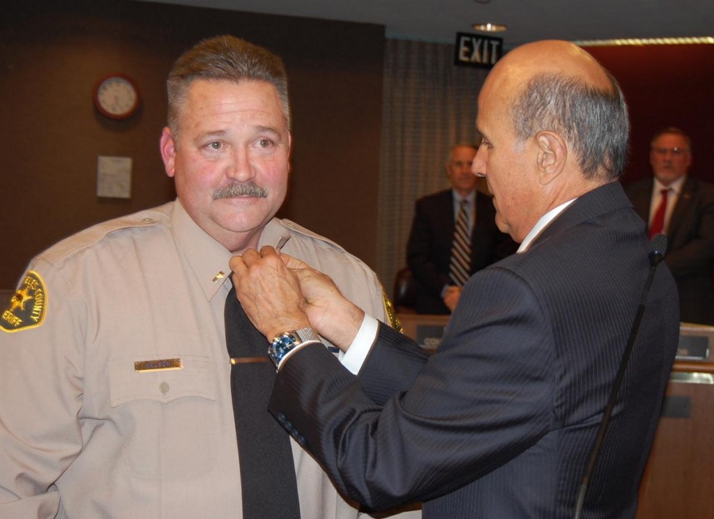 Los Angeles County Sheriff Lee Baca pins captain's bars on Pat Nelson, after promoting Nelson from Lieutenant to Captain at Tuesday's council meeting.
