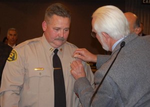 Mike Nelson pins on his son's badge. Baca said he and the elder Nelson shared a radio car in East Los Angeles in 1966. 