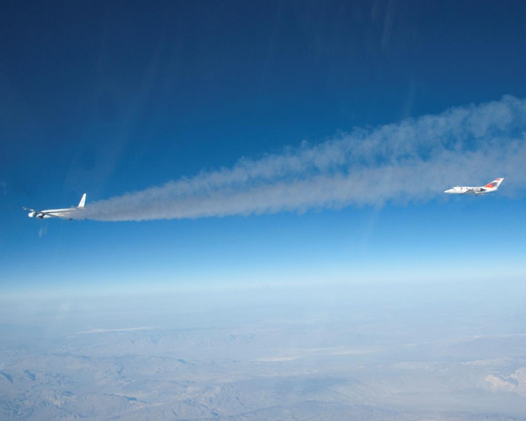 Flying some 500 feet behind NASA's DC-8 flying laboratory, a heavily instrumented HU-25 Falcon measures chemical components of the exhaust streaming from the DC-8's engines burning a 50/50 mix of conventional jet fuel and a plant-based biofuel during the 2013 ACCESS biofuels flight tests. (Image courtesy NASA)