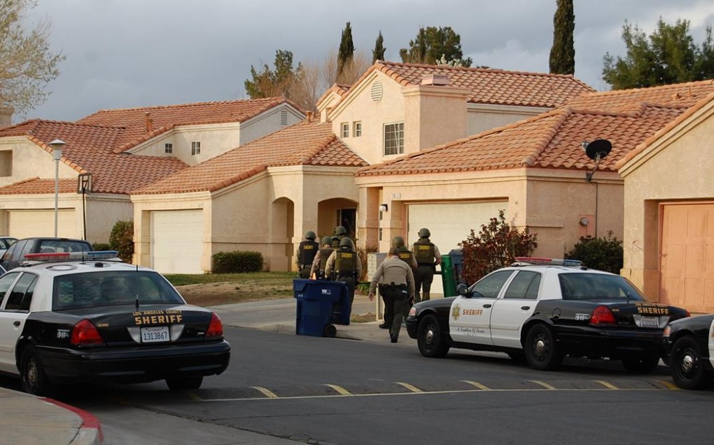 Deputies approach a home on Thursday morning 37600 block of Harvey Street in Palmdale. During the search deputies found several documents with gang writings, Gregg said. The juvenile who lives at the home was involved in a group assault on Jan. 17.
