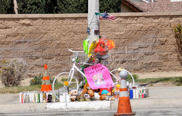 A makeshift memorial, that includes dozens of candles, stuffed animals and flowers, marks the Palmdale intersection where Michael “Speedy” Valenzuela was struck by a school bus on March 25. A white bike showed up at the memorial on Saturday. It’s the exact model that Valenzuela always wanted and had hoped to purchase, his friends said.