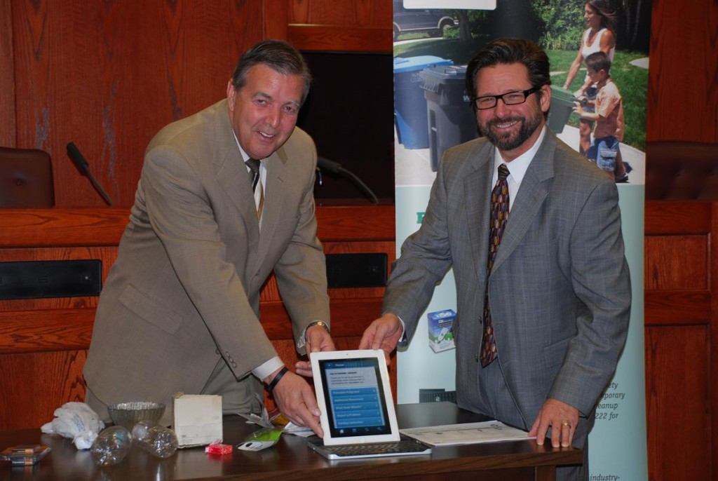 Palmdale Mayor Jim Ledford, left, and Waste Management’s Doug Corcoran display the City’s new “my-waste” phone app on an IPad.