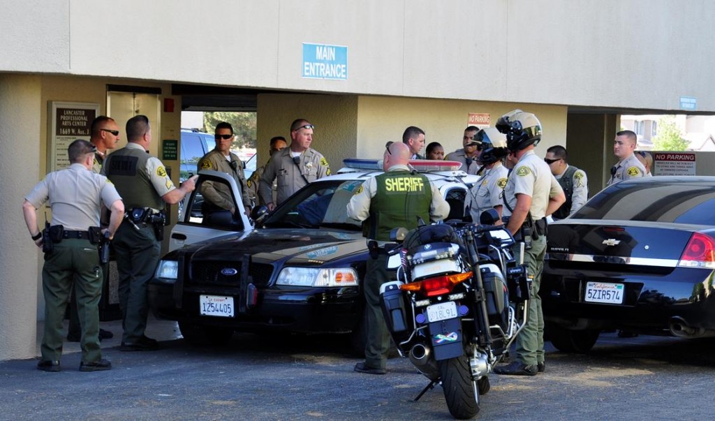Deputies surround a patrol car in front of a medical office building where an attempted murder suspect was taken into custody Wednesday afternoon.