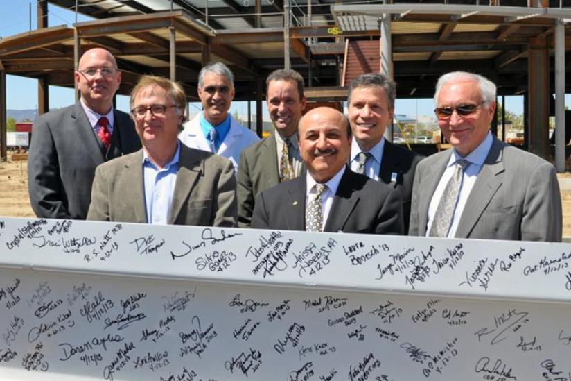 Executives from City of Hope, Antelope Valley Hospital, G.L. Bruno Associates, Inc., and local government officials pose with the beam prior to installation. (L to R) Norm Hickling, Abdallah Farrukh, M.D., Vijay Trisal, M.D., Senator Steve Knight, Edward Mirzabegian, Harlan Levine, M.D., Gary L. Bruno.